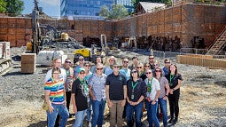 A group of people standing in front of a construction site